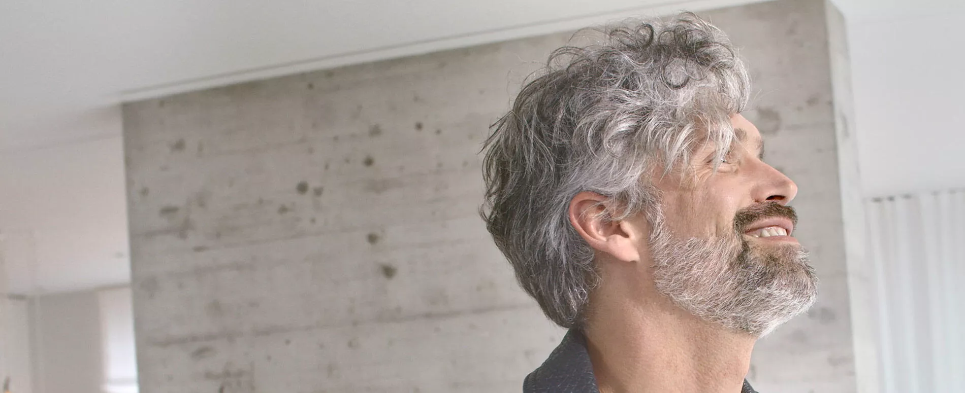 Fotografía de perfil de un hombre con cabello canoso parcial gracias a True Grey de Wella Professionals