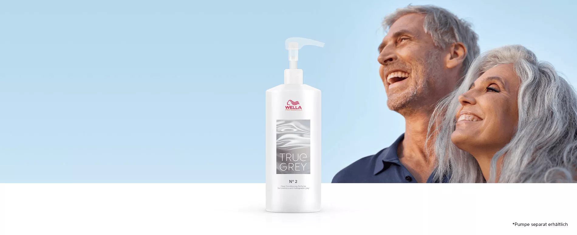 Ein Mann und eine Frau mit natürlichem grauen Haar lachen in der Sonne mit einer Flasche True Grey Conditioning Perfector im Vordergrund