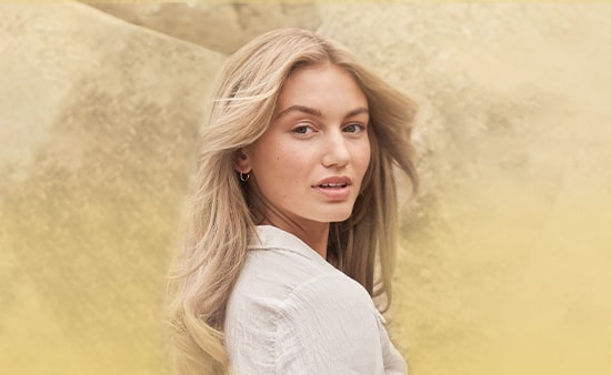 Dos mujeres, una con cabello rizado oscuro y la otra con cabello rubio, lacio y largo.