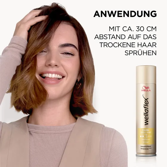 Braunhaariges Model, das sich von Wellaflex das Farbbrillanz Haarspray in die Haare sprüht. Das Haarspray sollte aus einer Entfernung von 30 Zentimetern auf das Haar aufgetragen werden.