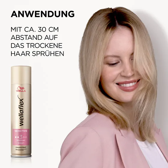 Blondhaariges Model, das sich von Wellaflex das Sensitive Haarspray in die Haare sprüht. Das Haarspray sollte aus einer Entfernung von 30 Zentimetern auf das Haar aufgetragen werden.