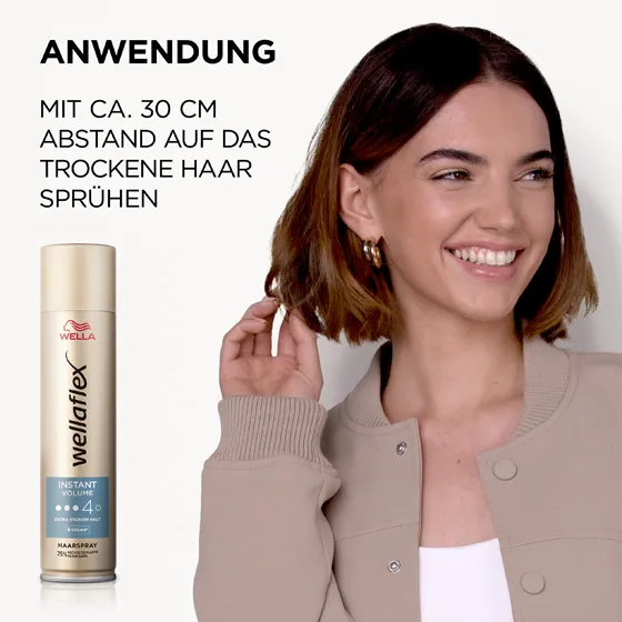Braunhaariges Model, das sich von Wellaflex das Instant Volumen Haarspray in die Haare sprüht. Das Haarspray sollte aus einer Entfernung von 30 Zentimetern auf das Haar aufgetragen werden.